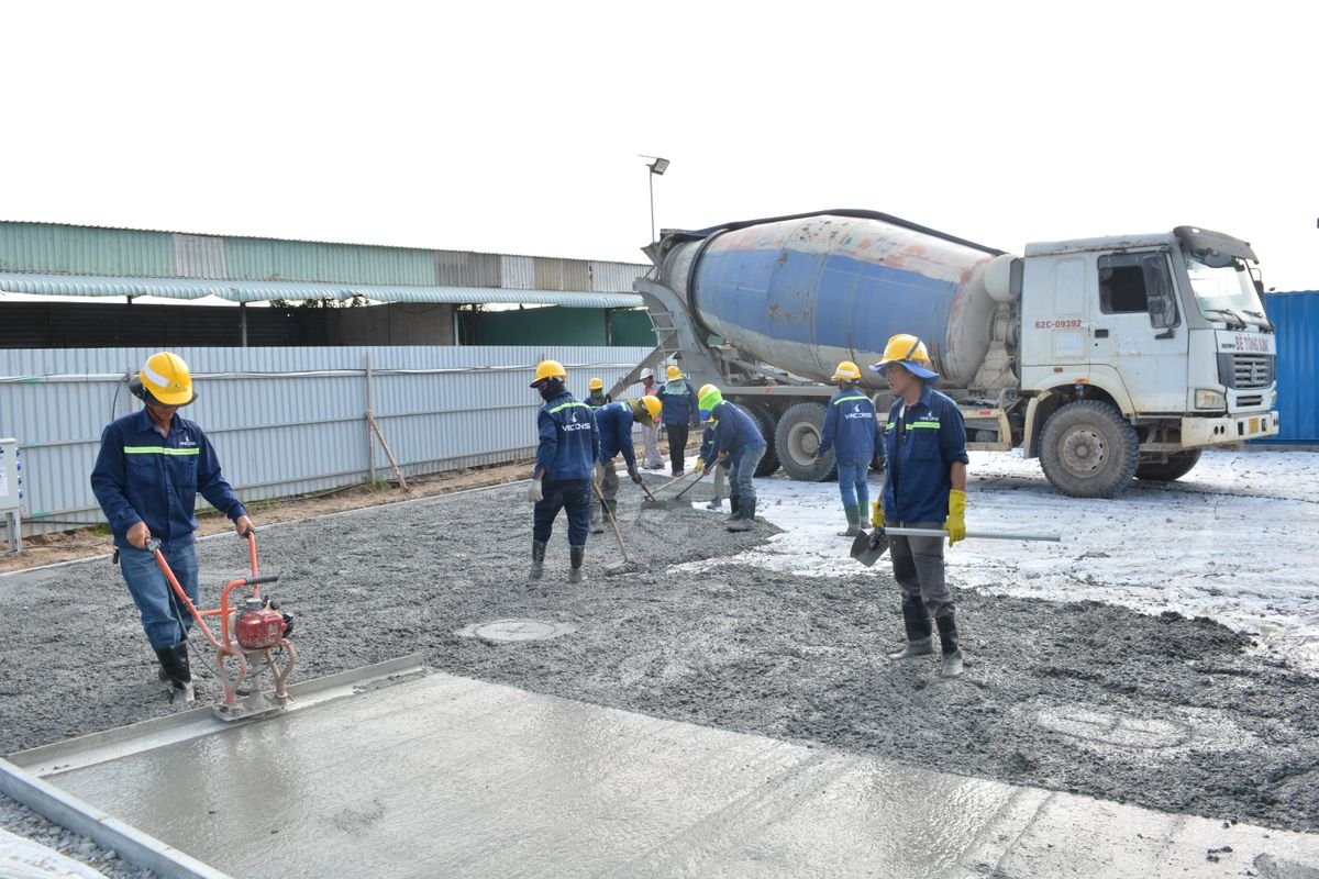 Crew placing and levelling fresh concrete